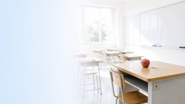 Empty empty teacher desk in bright classroom, teacher shortage and education crisis and recruitment concept banner with copy space
