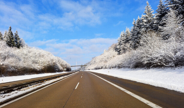 Fahrt auf der winterlichen Bundesautobahn A7 bei Heidenheim an der Brenz durch eine tief verschneite Waldlandschaft, Baden-W&uuml;rttemberg, Deutschland