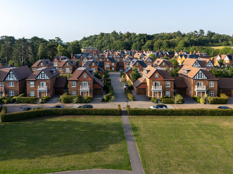 Aerial view of luxury new build homes featuring brick facades and tiled roofs, surrounded by manicured hedges and green lawns in Maidenhead, England, United Kingdom.