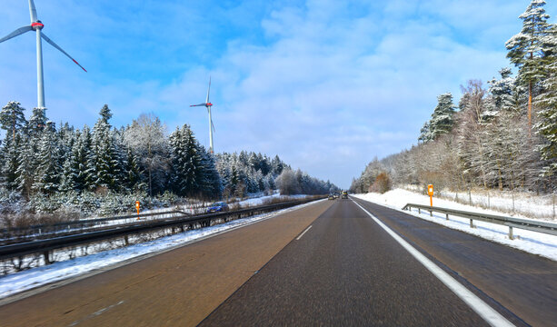 Fahrt auf der winterlichen Autobahn A7 in Baden-W&uuml;rttemberg nach dem Virngrundtunnel in Richtung Norden mit den Windkraftanlagen des Windparks Ellwanger Berge