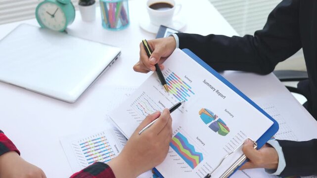 Business people collaborating on financial data and performance charts. Corporate strategy, analytics, marketing, revenue, growth, teamwork, conference room, 4K.