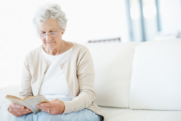 Obraz premium Relax, book or old woman on sofa with reading, fantasy novel or insight in literature hobby. Chill, glasses or senior person in house with fairytale, peaceful moment or fiction story in retirement.