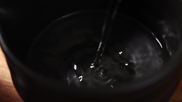 Pour hot water into the cup for processing the matcha.