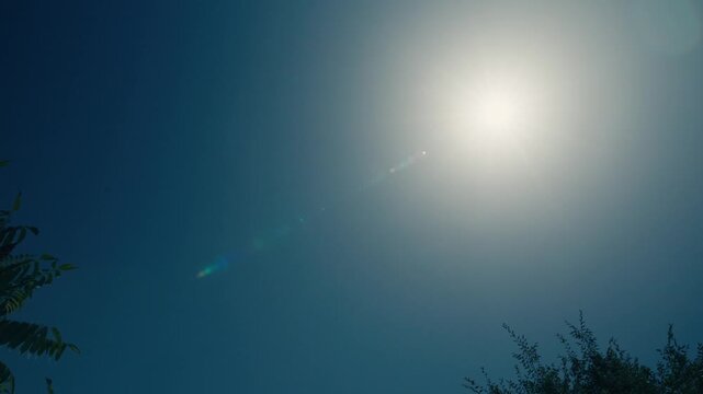 Burning sun during extreme heatwave with lens flare. Concept of climate change and summer weather danger.