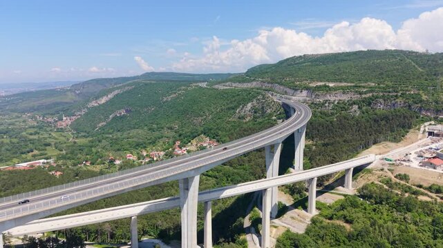 Side drone view of Črni Kal Viaduct with vehicles crossing in Slovenia.