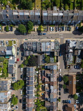 Aerial view of Ealing residential streets featuring rows of terraced houses, private gardens, and parked cars, London Borough of Ealing, England, United Kingdom.
