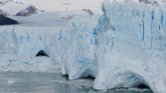 Perito Moreno Glacier reveals crevasses, melt cavities and compressed ice layers above Argentino Lake in Los Glaciares National Park near El Calafate, Patagonia, Argentina, drone orbit shot.