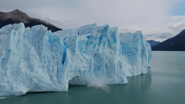 Perito Moreno Glacier calves into Argentino Lake in Los Glaciares National Park near El Calafate, Patagonia, Argentina, as a section of the ice front collapses into the water, drone shot