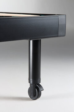 Close up of a bed base with a wheeled leg