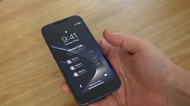 Missed calls from My Love fill a smartphone lock screen while a person holds the device in an indoor setting. Close-up smartphone notification concept emphasizing relationships, unanswered calls, and