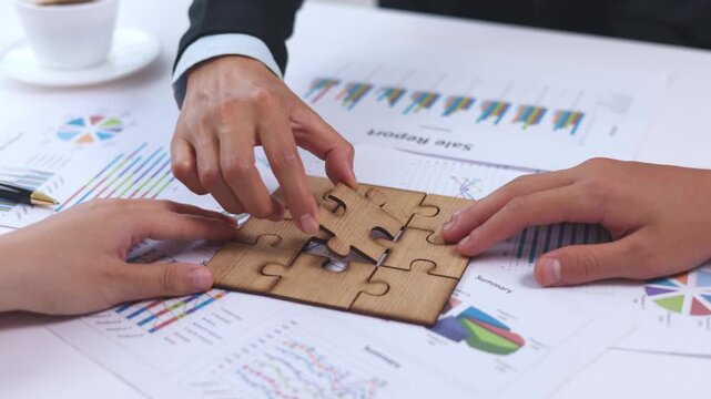 Business people working together to complete a jigsaw puzzle. Corporate strategy, teamwork, partnership, creativity, problem solving, productivity, innovation, 4K.