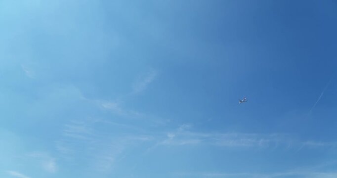 Aerial footage of an airplane flying through a clear blue sky, capturing a simple and peaceful aviation scene in bright daylight.