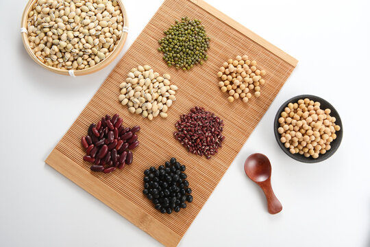 Various types of beans arranged on a bamboo mat for healthy cooking ingredients