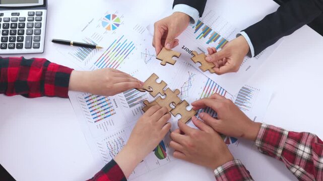 Business team assembling a jigsaw puzzle during a corporate meeting. Teamwork, collaboration, strategy, leadership, problem solving, success, office, innovation, 4K.