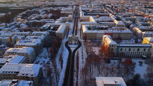 Snow covered Siegestor and Ludwigstrasse seen from above on a crisp winter morning, capturing Munich historic architecture and serene cold season atmosphere