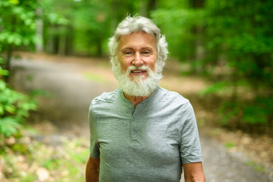 Senior man walk in the forest on a summer day