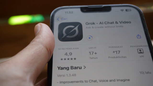 Purwokerto, Indonesia - 17 June 2026: Hand holding an iPhone displaying the Grok AI Chat and Video app listing on the Apple App Store.