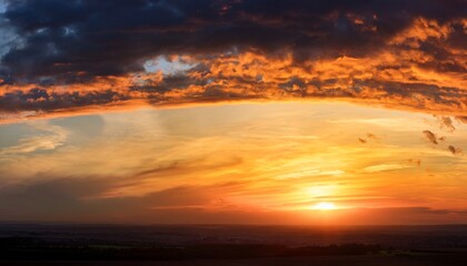 Fototapeta premium Panoramic Sunset Sky With Warm Golden Orange Hues And A Dark Band Of Clouds On The Horizon Romantic Evening Landscape