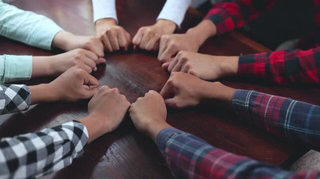 Business team stacking hands in a corporate office, symbolizing teamwork, collaboration, leadership, trust, success, motivation, partnership, unity, growth and business achievement in 4K.