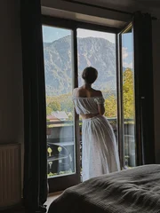Woman in White Dress Gazing Out Window at Mountains © Floral Deco
