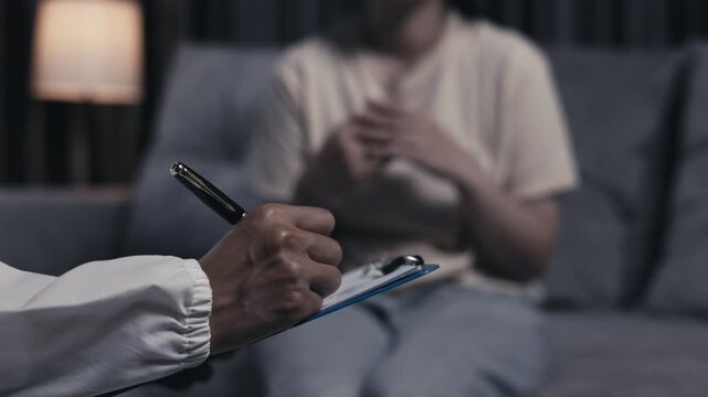 Caregiver recording symptoms of a teenager with depression during a mental health session. Healthcare, therapy, counseling, support, recovery, wellbeing, compassion, 4K.