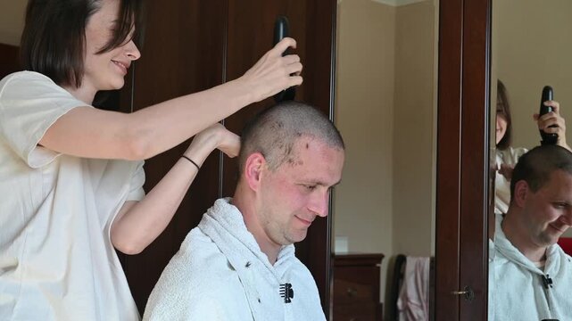 Woman Giving Her Husband a Buzz Cut at Home