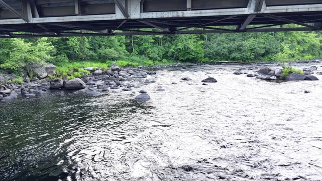 Moving up the Contoocook River in Henniker, NH under the the bridge on a quiet and calm spring evening 