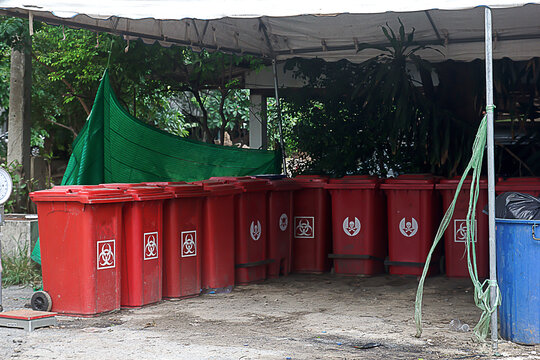 The building has a roof and is used for storing infectious waste in the hospital.