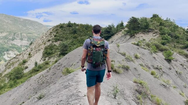 Randonneur qui avance sur une cr&ecirc;te face &agrave; un paysage grandiose 