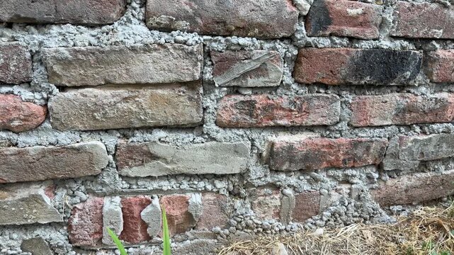 Bad bricklaying detail. Messy cement mortar and uneven bricks on construction site.