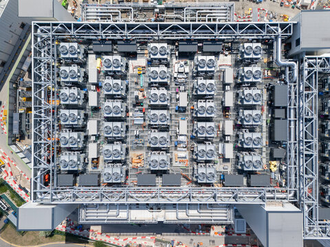 Aerial view of the Data Centre Roof featuring rows of industrial HVAC cooling units and complex ventilation piping in London, England, United Kingdom.