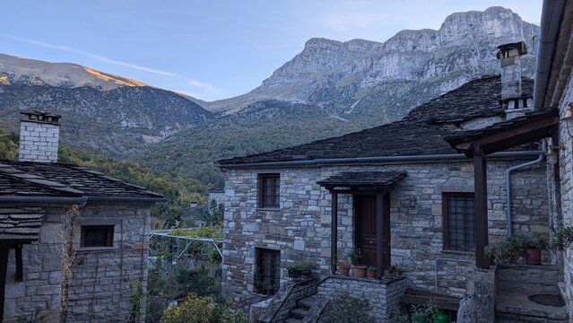 Traditional Stone Houses in a Mountain Village with Scenic Cliffs Background