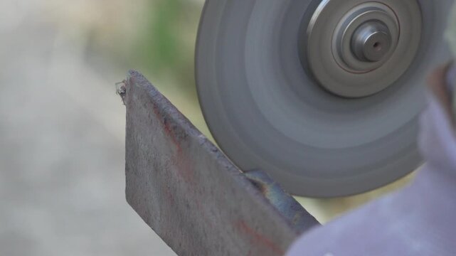 Grinding metal sparks grinding wheel cutting steel edge with high speed rotary tool in a professional metalwork shop workshop setting environment