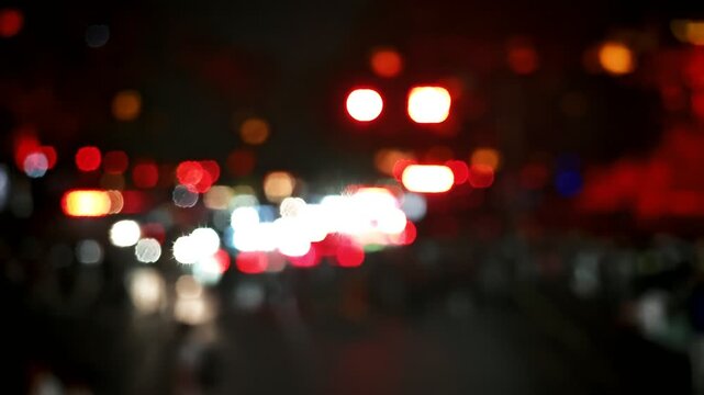 A soft, blurred nighttime cityscape with a vibrant tapestry of reds, whites