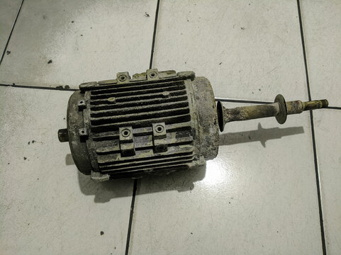 Old and dirty electric motor on tiled floor background