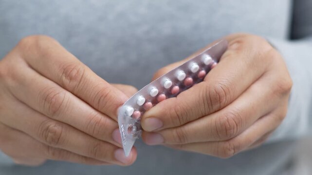 Close up woman hand contraceptive pill. Contraception reduces childbirth and pregnancy concept.