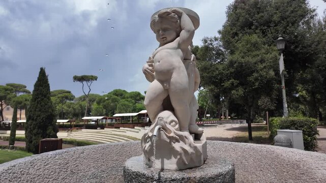 Close up of the putto riding a dolphin sculpture in Villa Borghese gardens