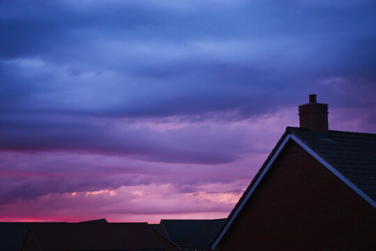 Hampton Water, Peterborough, England, UK - June 20 2026: Late sunset causing dramatic skyline with vibrant reds and blues over the rooftops of a peterborough suburb