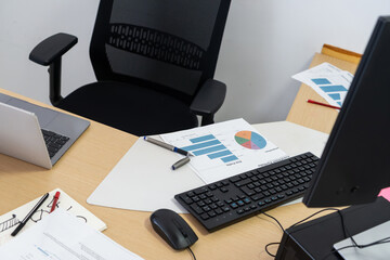 Naklejka premium Employee desk and chair with business reports and technology