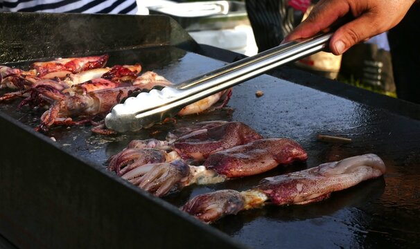 Fisherman grilled fresh squid from the sea on barbecue smoked, healthy Mediterranean food