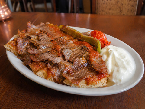  İskender kebab servido con carne d&ouml;ner sobre pan, salsa de tomate, mantequilla y yogur.