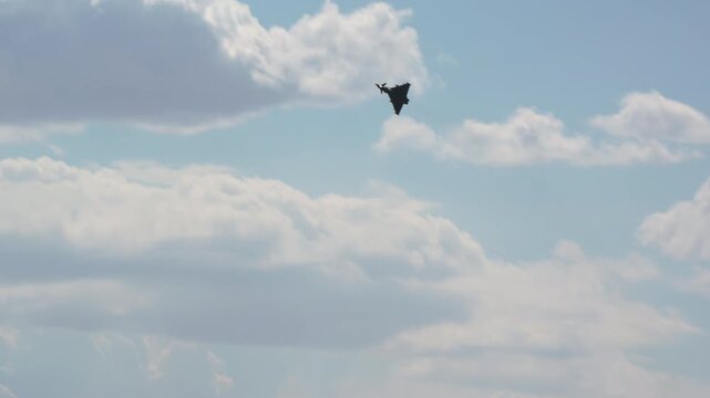 Military fighter jet aborting its landing approach and climbing away on a go around, warplane retracting its landing gear as it powers up, combat aircraft in a training pass