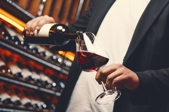 Man in Jacket Pouring Red Wine at Bar