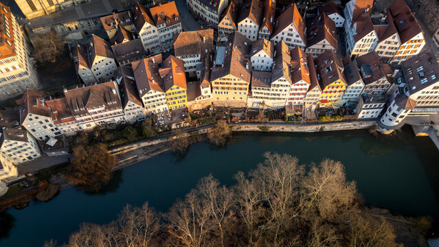 Aerial view of the historic old town of Tubingen along the Neckar river, featuring traditional timber-framed buildings and bare trees in Tubingen, Baden-Wurttemberg, Germany.