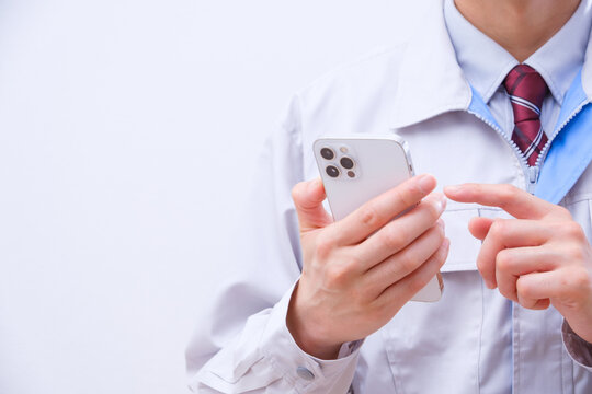 スマートフォンを操作する作業着の男性