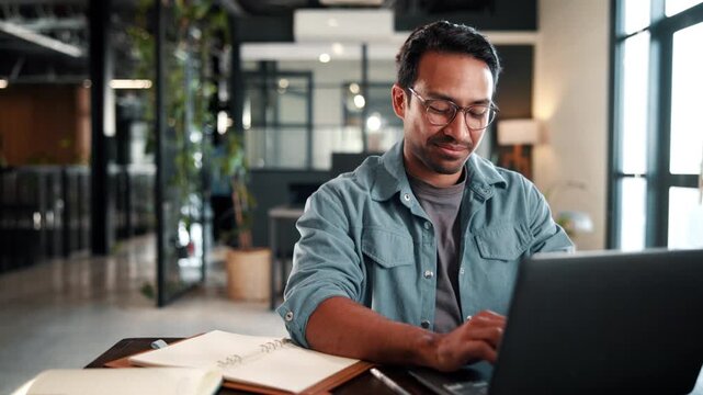 Happy, man and typing on laptop in office for publication feedback, editing process and approval. Creative, editor and tech at publishing agency for article comments, fact check story and submission
