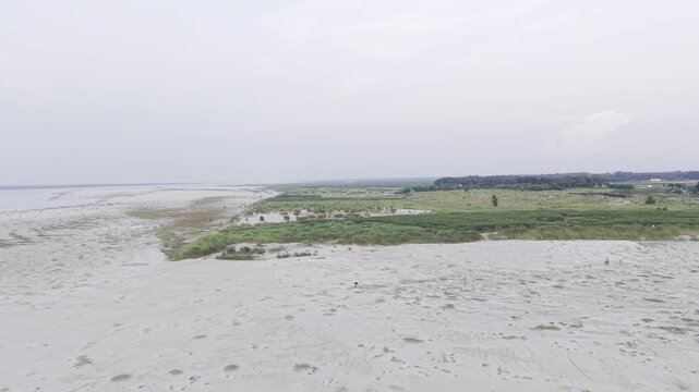 A cinematic low-altitude drone flight over the sandy riverbank at the Gorai Confluence in Kushtia, Bangladesh. 