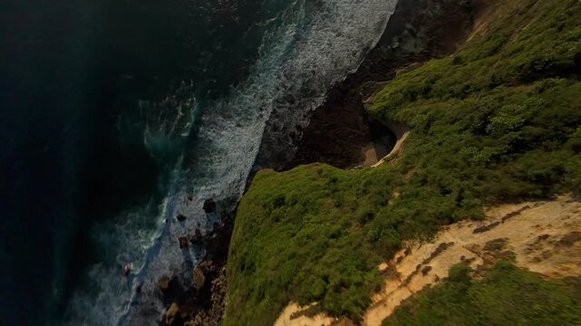 Extreme FPV Drone Dive Down Karang Boma Cliff Toward Powerful Ocean Waves, First Person Descent Above Rocky Shoreline And Hidden Cove, Adrenaline And Freedom