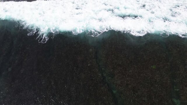 Top Down Aerial Drone View of Ocean Waves Crashing on Sandy Beach
