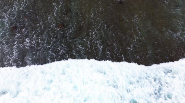 Top Down Aerial Drone View of Ocean Waves Crashing on Sandy Beach